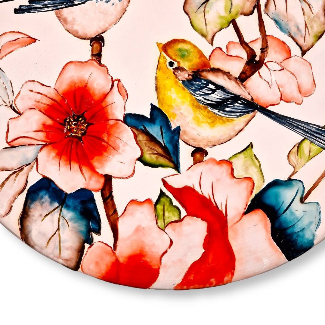 Plato de cerámica de 25 cm pintado a mano con un finísimo diseño persa de pájaros y flores brillantes esmaltados sobre un fondo blanco mate.