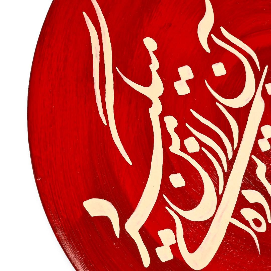 Plato de cerámica rojo de 29 cm pintado a mano con un poema de Daniel Rakhshani empleando un elegante diseño de caligrafía persa "Nastaliq".