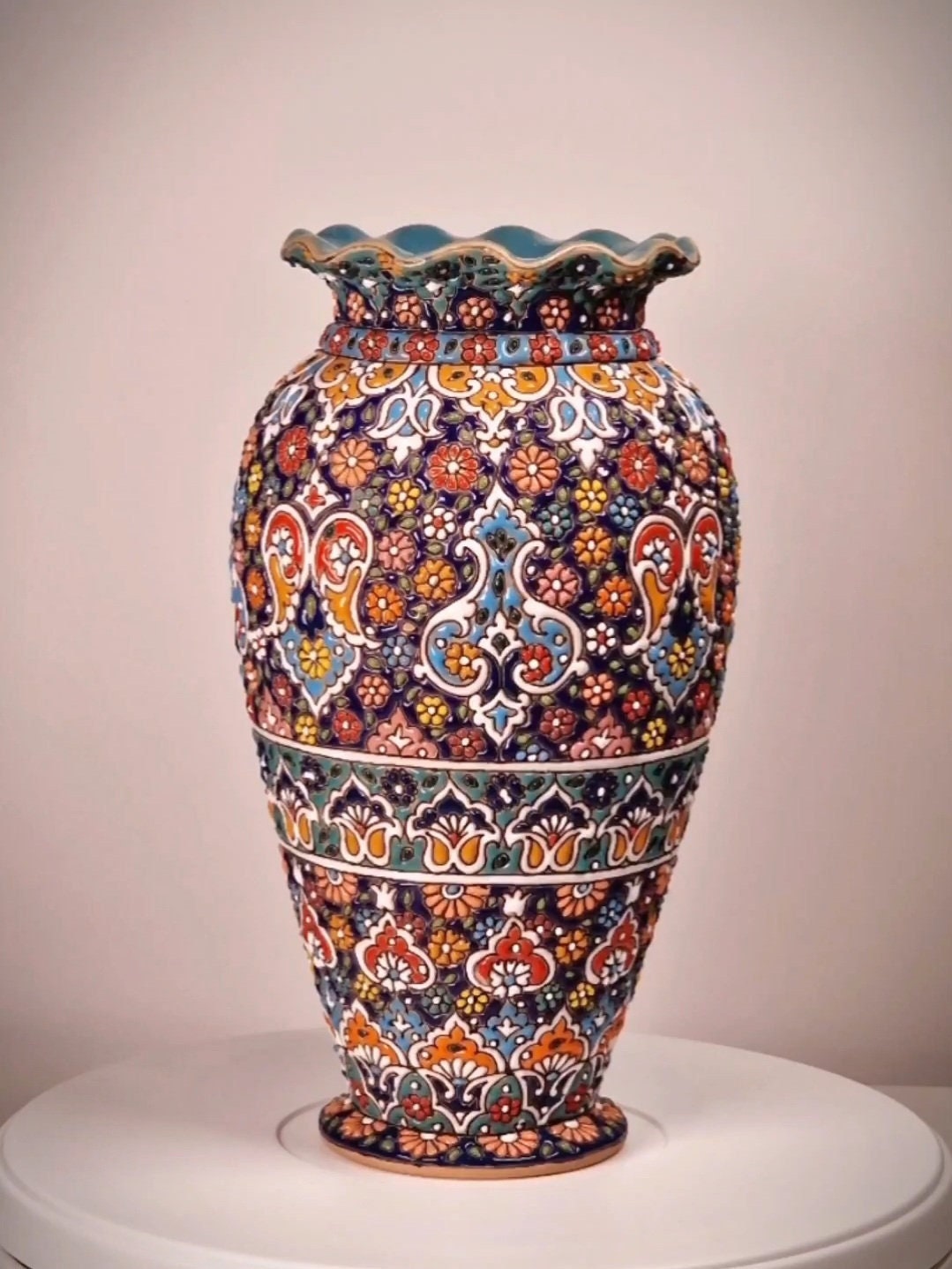 Jarrón de cerámica elaborado y decorado a mano mediante el arte persa del "minakari" o esmaltado con un diseño geométrico-floral en relieve.