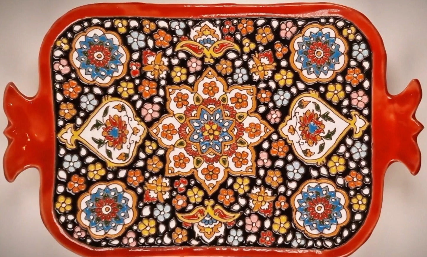 Bandeja de cerámica en forma de granada decorada a mano mediante el arte persa del "minakari" o esmaltado con un colorido diseño en relieve.