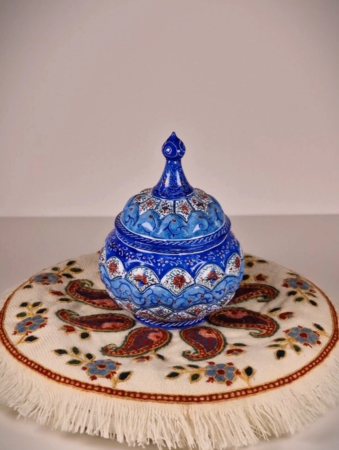 Azucarero de cobre pintado a mano mediante el arte persa del "minakari" o esmaltado con un diseño geométrico-floral en tonos azules y rojos.